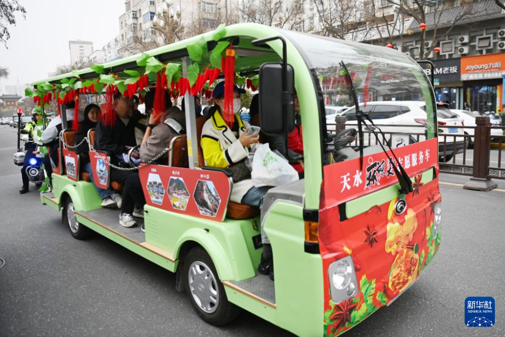 3月16日，在天水市秦州区，游客乘坐免费的“天水麻辣烫志愿服务车”前往景区。新华社记者　范培珅　摄