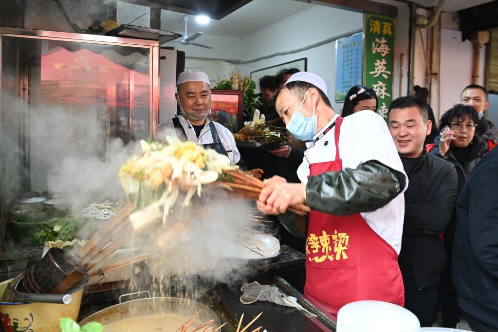 3月16日，在天水市秦州区的天水名优小吃城一麻辣烫店，商家为游客加工麻辣烫。新华社记者　范培珅　摄
