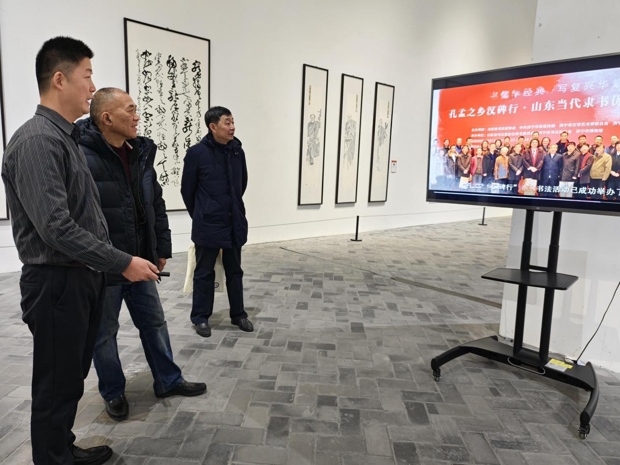 西泠印社社员江继甚（左二）在展厅观看专题片