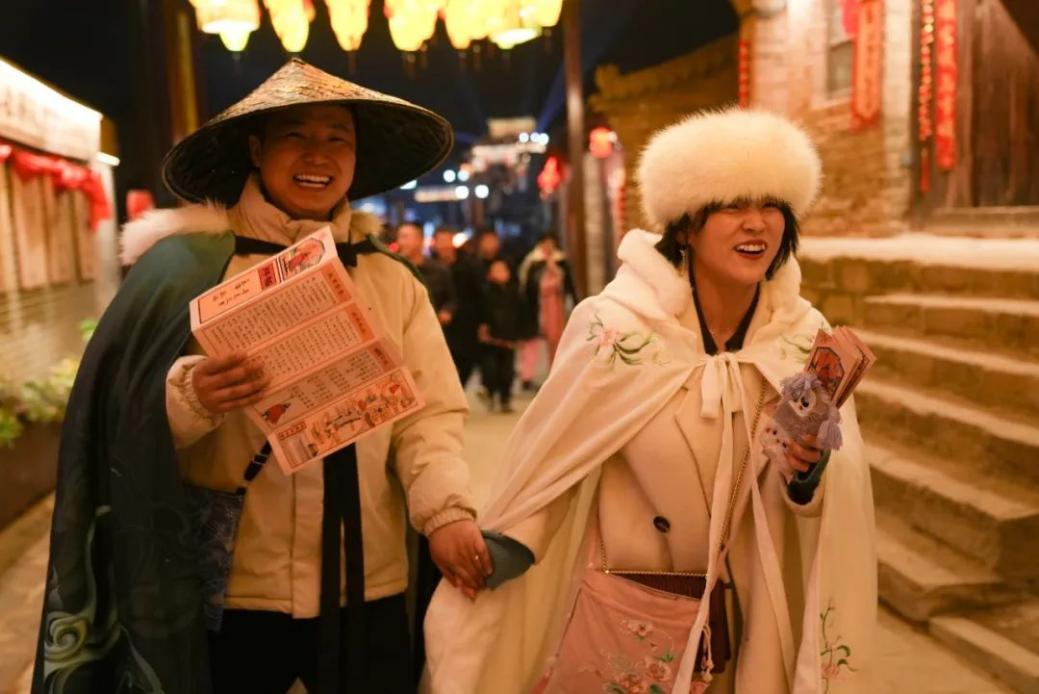 波罗古堡街道上，游客正在快乐体验寻觅波罗沉浸式互动游戏。