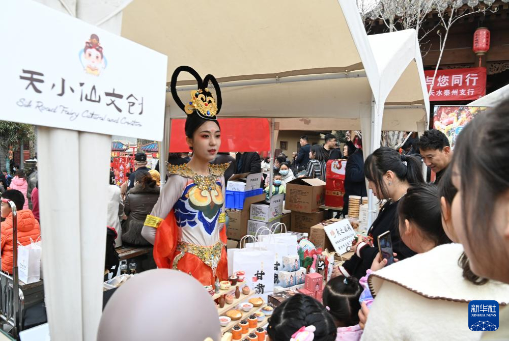 3月16日，游客在天水市天水古城举办的“天水麻辣烫吃货节”现场选购文创产品。新华社记者　范培珅　摄