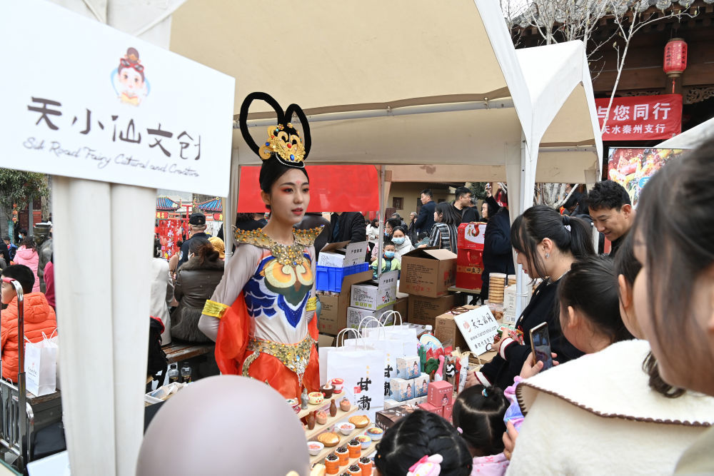 3月16日，游客在天水市天水古城举办的“天水麻辣烫吃货节”现场选购文创产品。新华社记者　范培珅　摄