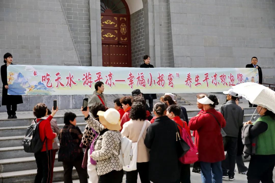 工作人员拿着横幅欢迎游客的到来