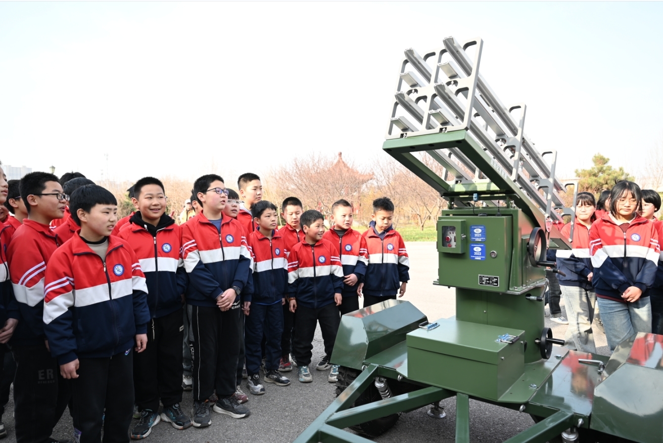 学生们参观人工影响天气火箭发射架