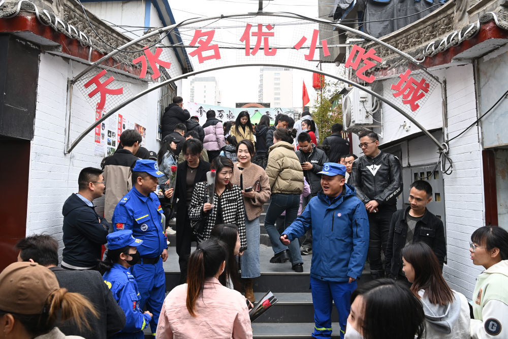 3月16日，在天水市秦州区的天水名优小吃城门口，蓝天救援队队员为游客提供秩序疏导服务。新华社记者　范培珅　摄