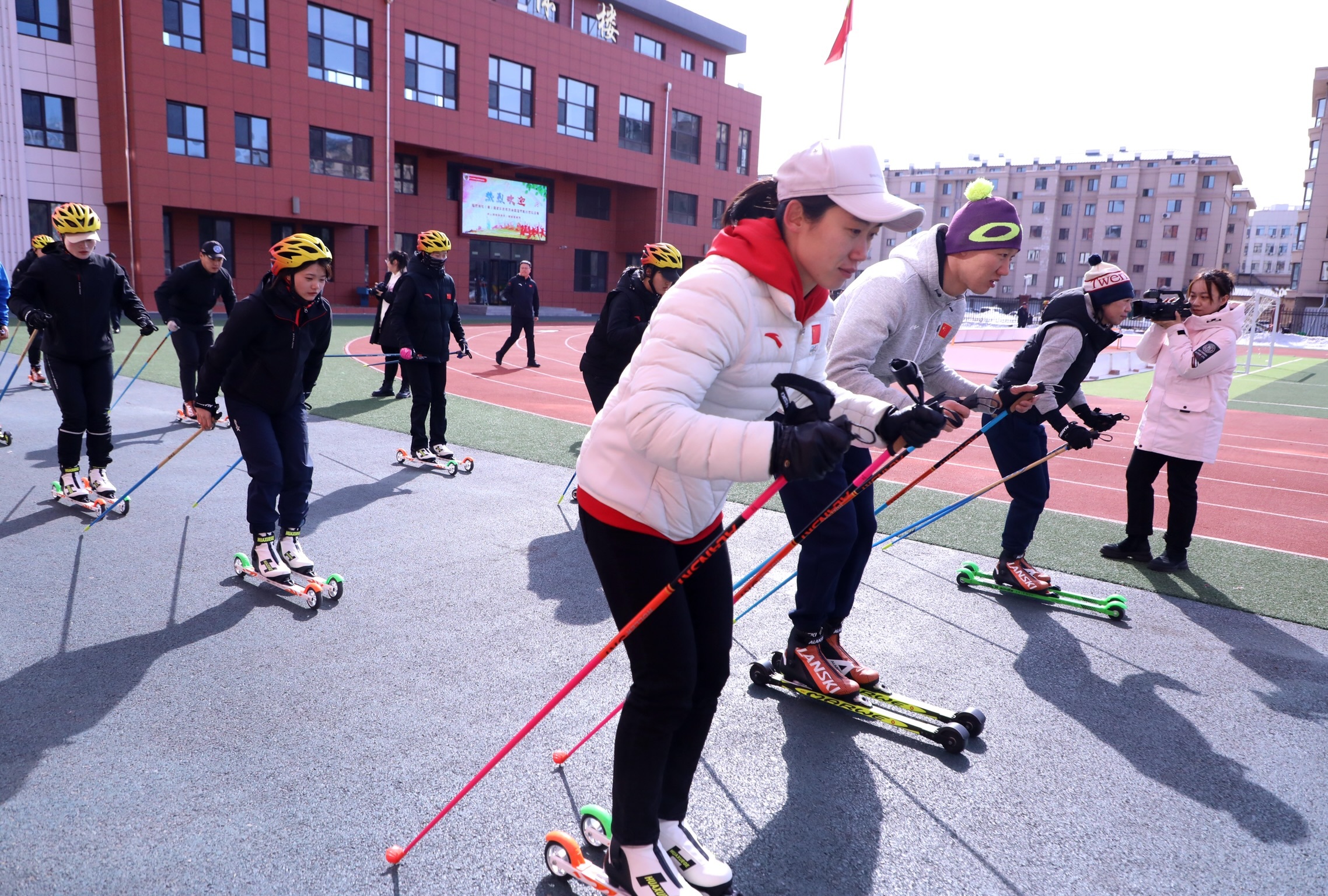 教师在滑雪教练的指导下，练习双摆臂技术的单支撑滑行技术