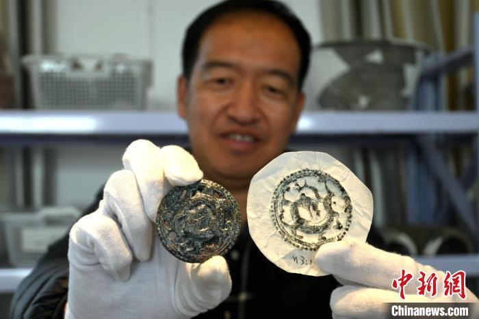 2022年3月，雷建红展示雄安新区南阳遗址出土的铜泡(资料图)。中新社记者 翟羽佳 摄