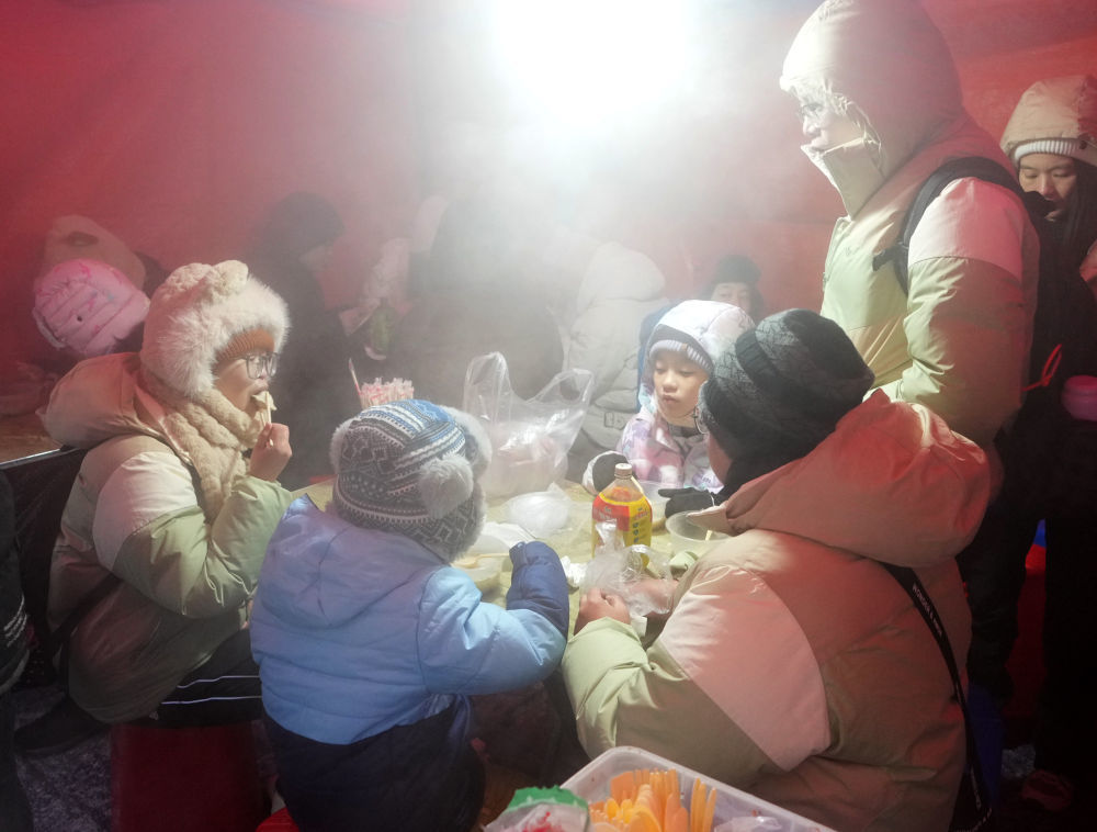 2024年1月，在哈尔滨红专街早市，来自广州的游客在品尝粘豆包（1月22日摄）。新华社记者　王毓国　摄