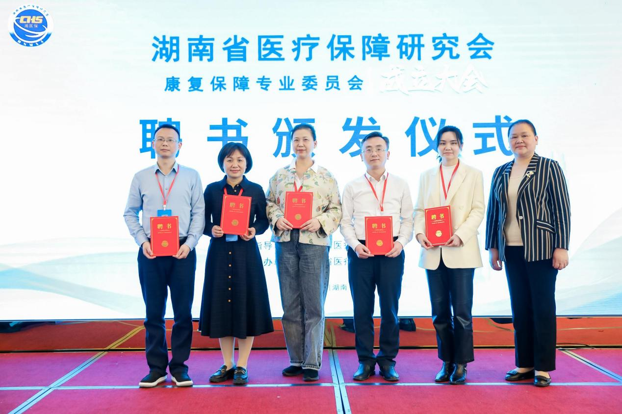 湖南省医疗保障研究会会长王秧球(右一)为当选的第一届委员会副主任委员王庆红(左三)、李旭红(左二)、方翠霓(右二)、肖 乐(左一)、周君(右三)颁发聘书