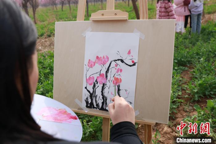 3月28日，一女子正在梅花种植基地写生。尚长治 摄