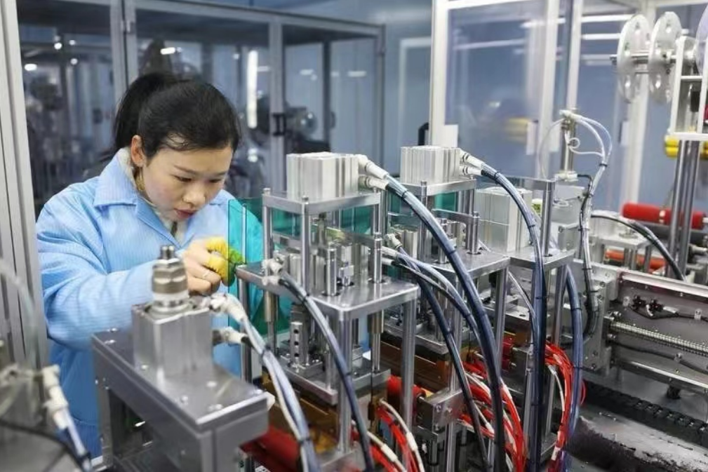 鹰潭万成光学科技有限公司内，工作人员认真操作激光焊接生产设备。作者供图