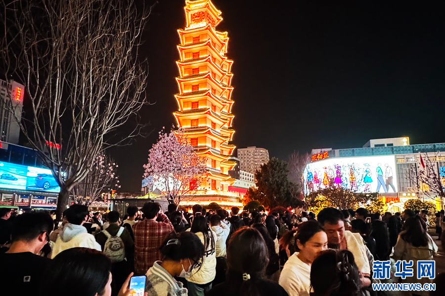 3月24日晚，郑州市二七塔，游客在排队拍摄玉兰花。