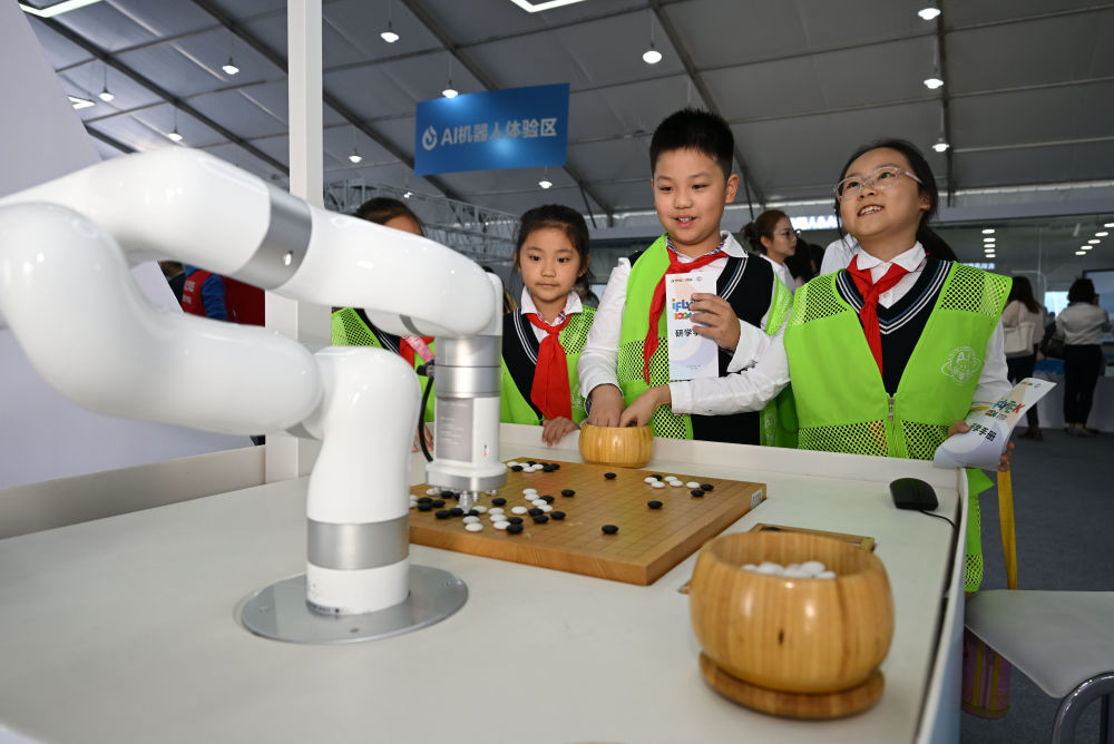 2023年10月24日，小朋友们在第六届世界声博会上参观体验一款弈棋机器人。新华社记者 周牧 摄