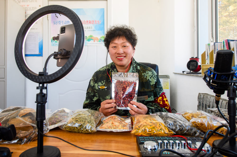 何喜艳在阿木尔林业局龙河林场龙河管护站内展示当地特产(2024年3月18日摄)。曾依托伐木养家糊口的何喜艳,停伐后在阿木尔林业局龙河林场龙河管护站工作。新华社记者 陈益宸 摄