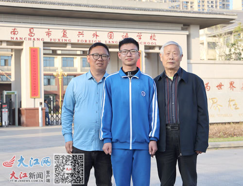 熊奕涵(中)及其父亲(左)与教练张千顺(右)在校门口合影留念。