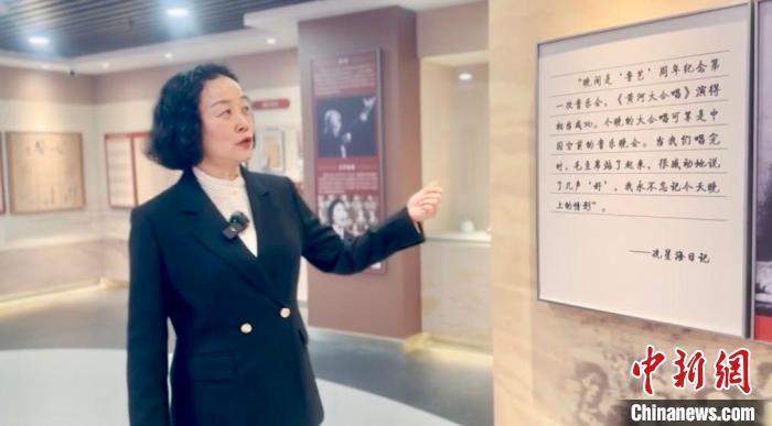 图为黄炜在《黄河大合唱》展馆内向记者讲解。高莹 摄