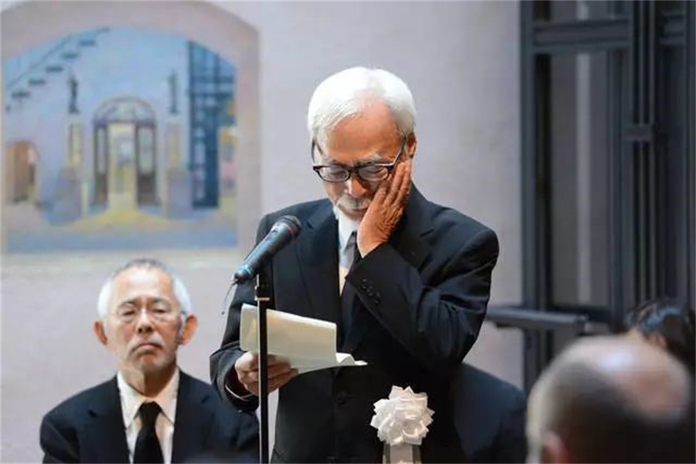 宫崎骏在高畑勋葬礼上致辞，后景为铃木敏夫