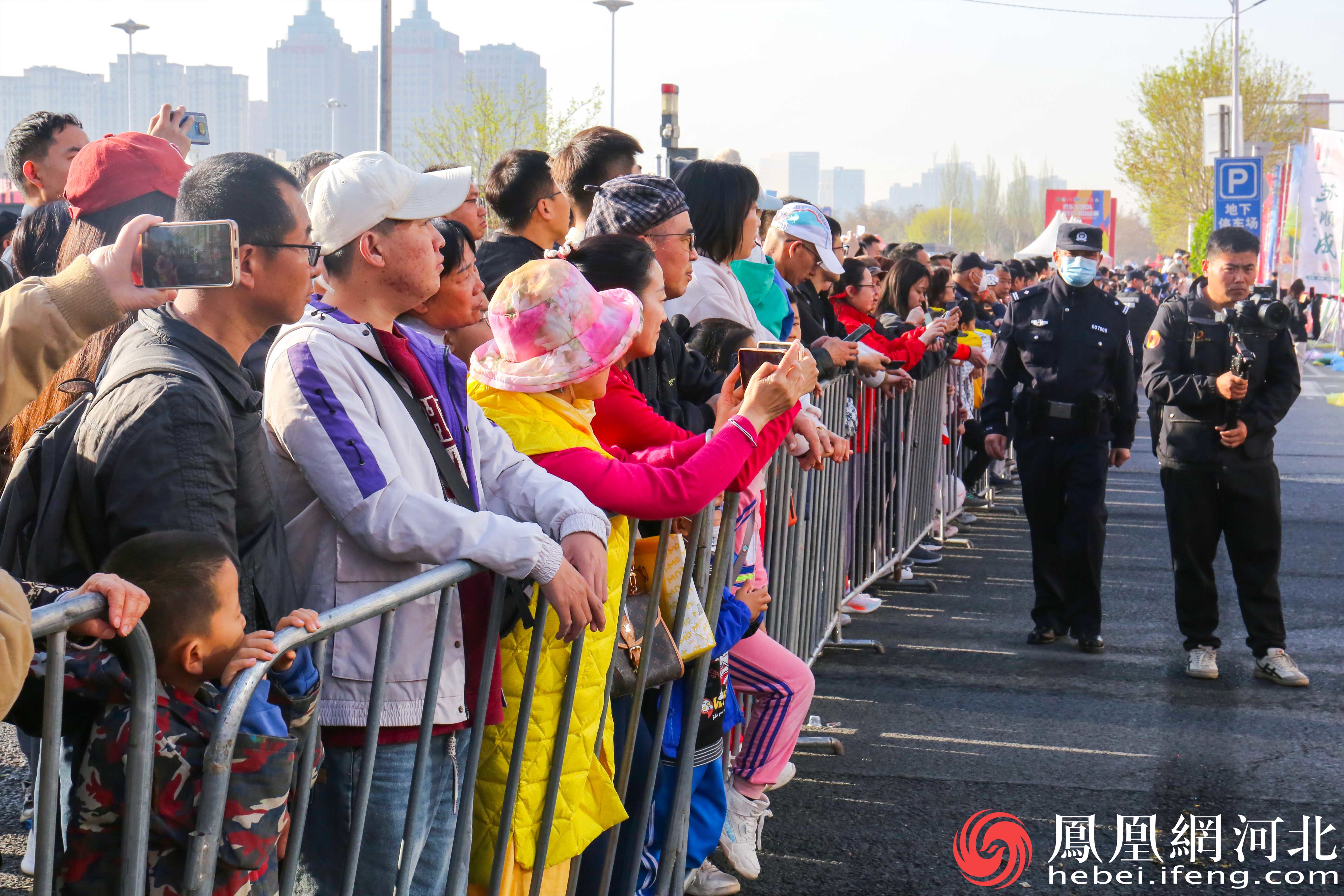 马拉松比赛吸引了大量观众前来观看热闹非凡。观众们聚集在赛道两旁，为比赛增添了浓厚的氛围。