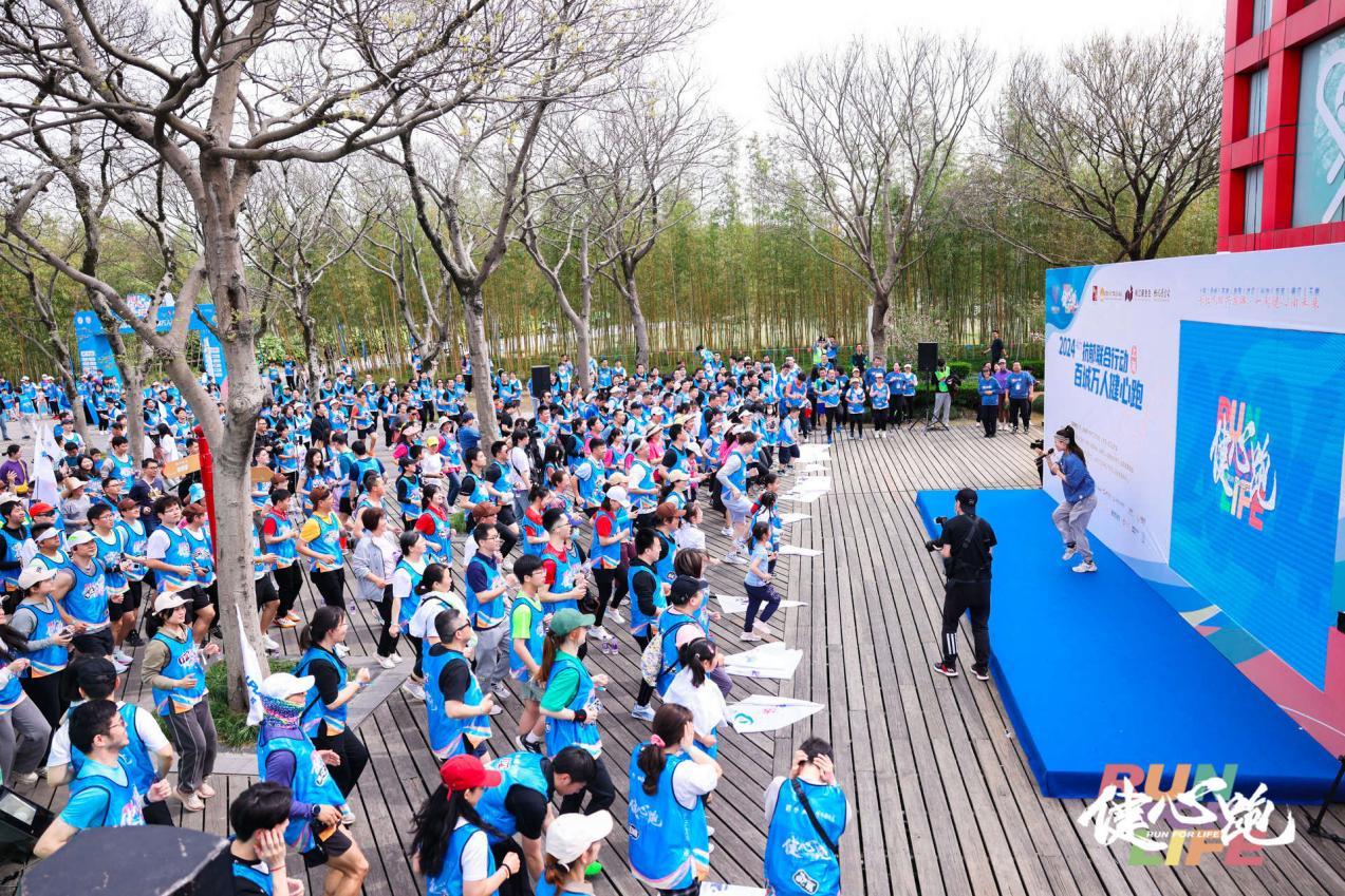 3月30日,“百城万人健心跑”线下活动上海站,跑者正在运动达人带领下进行跑前热身