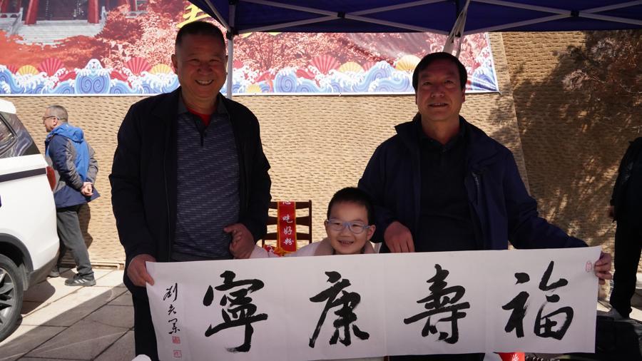 通渭县书法家协会主席刘宏业在天水古城做推广(右一)