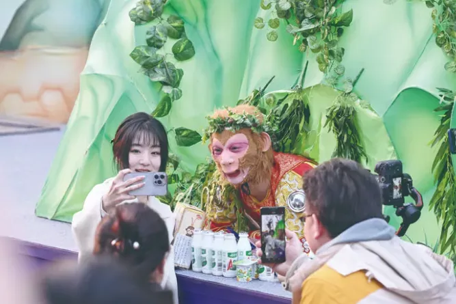 游客在长春市动植物公园与“雪饼猴”互动。图片来源:长春日报