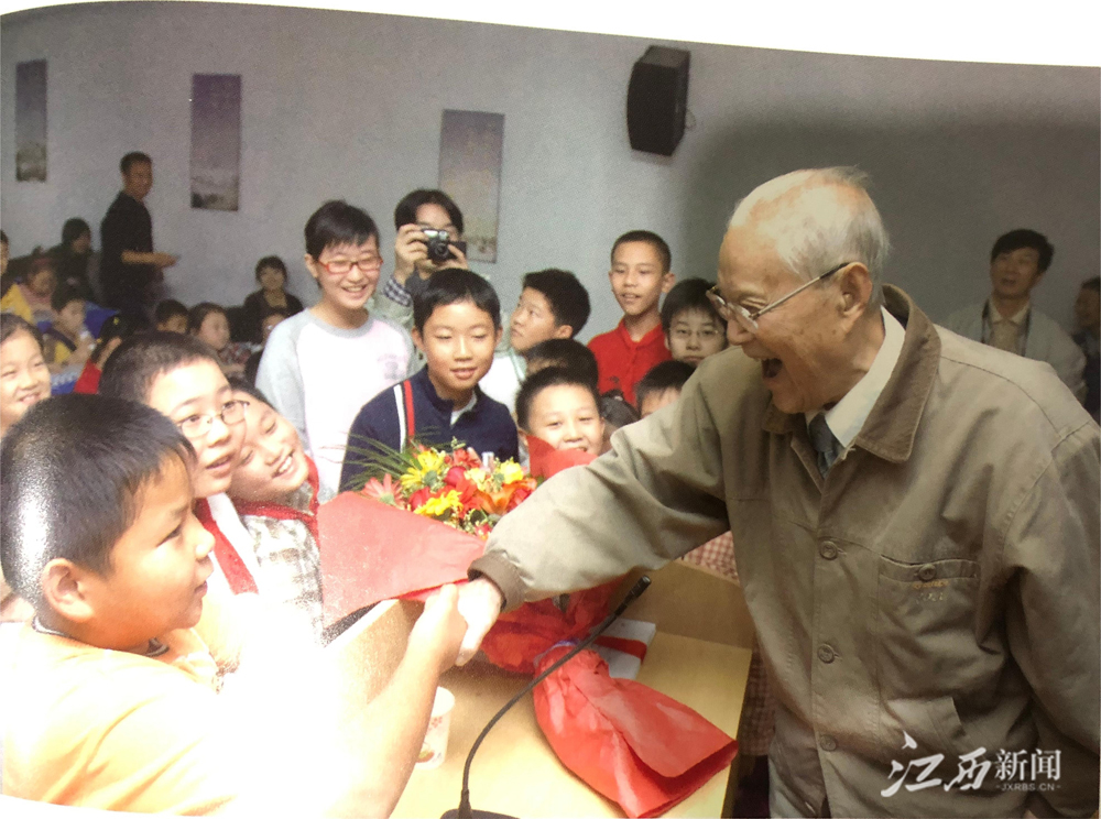 ▲2006年，张力雄将军（右一）走进学校开展革命传统教育，与小学生亲切生握手。｜林文金供图