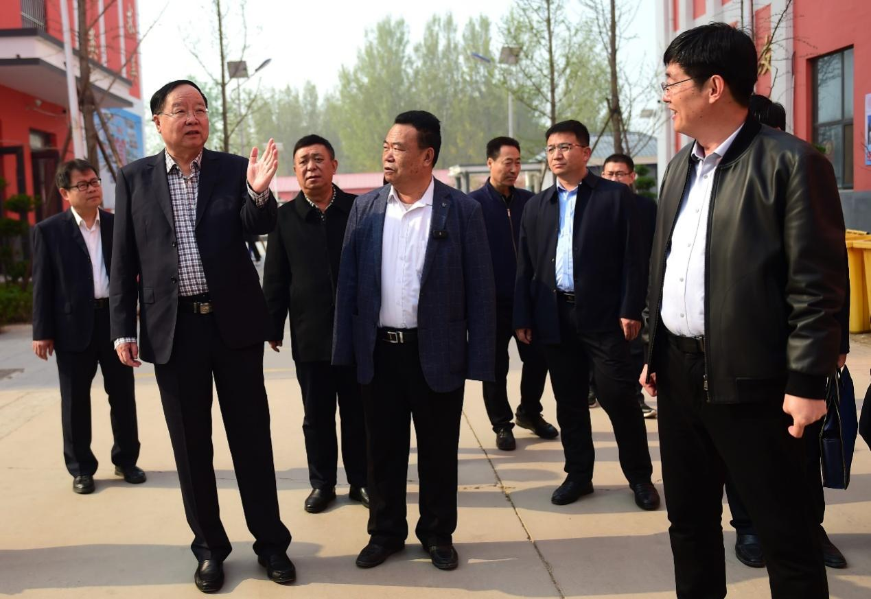 张文茂（左一）在沧县衡实高级中学与学校负责人交流。