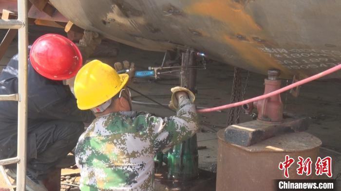 图为都昌造船总厂的工人正在对船体进行切割、降温。熊希成 摄