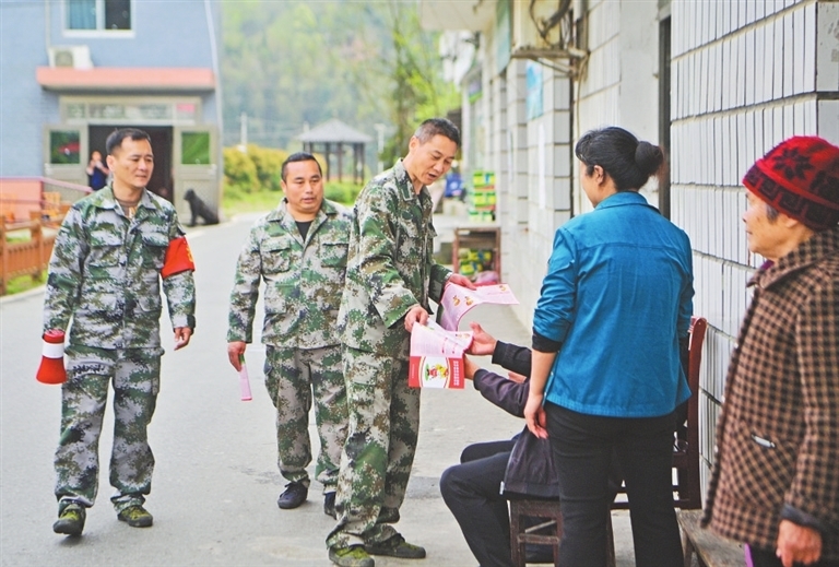 刘泽新和队员们向周边村民发放防火宣传册,提高村民的森林防火意识。