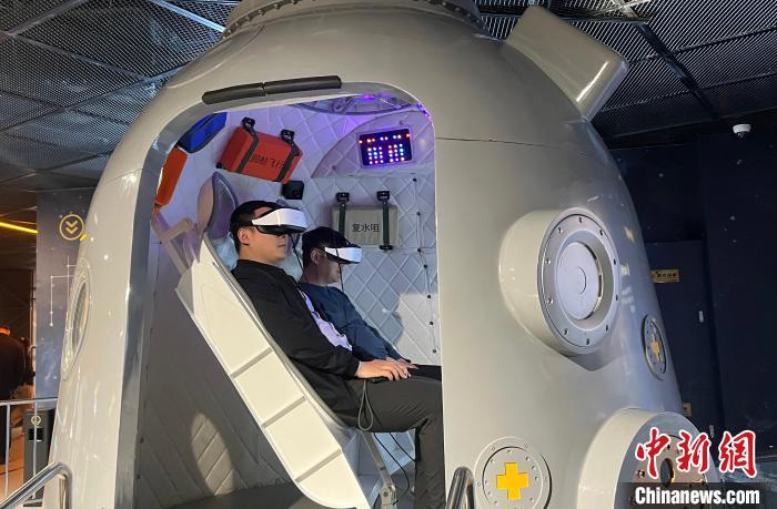 图为民众在东方航天港航天科普馆体验“神舟返回舱”VR项目。王娇妮 摄