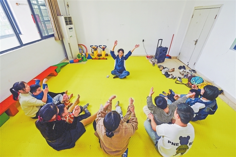 特教老师陈可指导家长带着孩子进行音乐治疗。