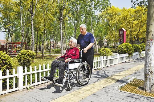 4月17日，张利霞用轮椅推着母亲外出散心。河北日报通讯员 韩富强摄
