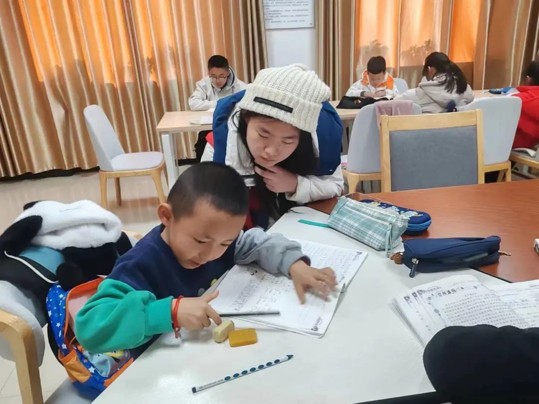 △昌丰里社区寒假托管班的志愿者在认真辅导孩子们写作业