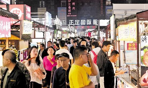 4月16日，正定小商品夜市人头攒动，游客在购买各色美食。河北日报记者 史晟全摄