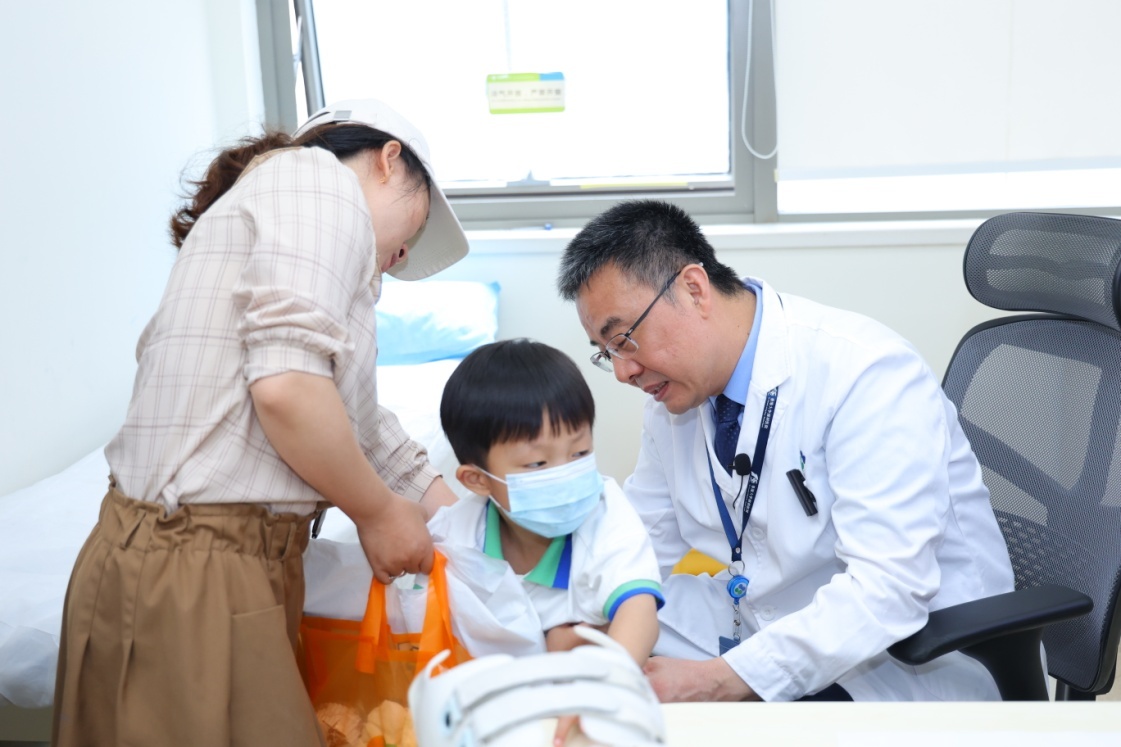 图说:陶惠人教授为小患者检查脊柱