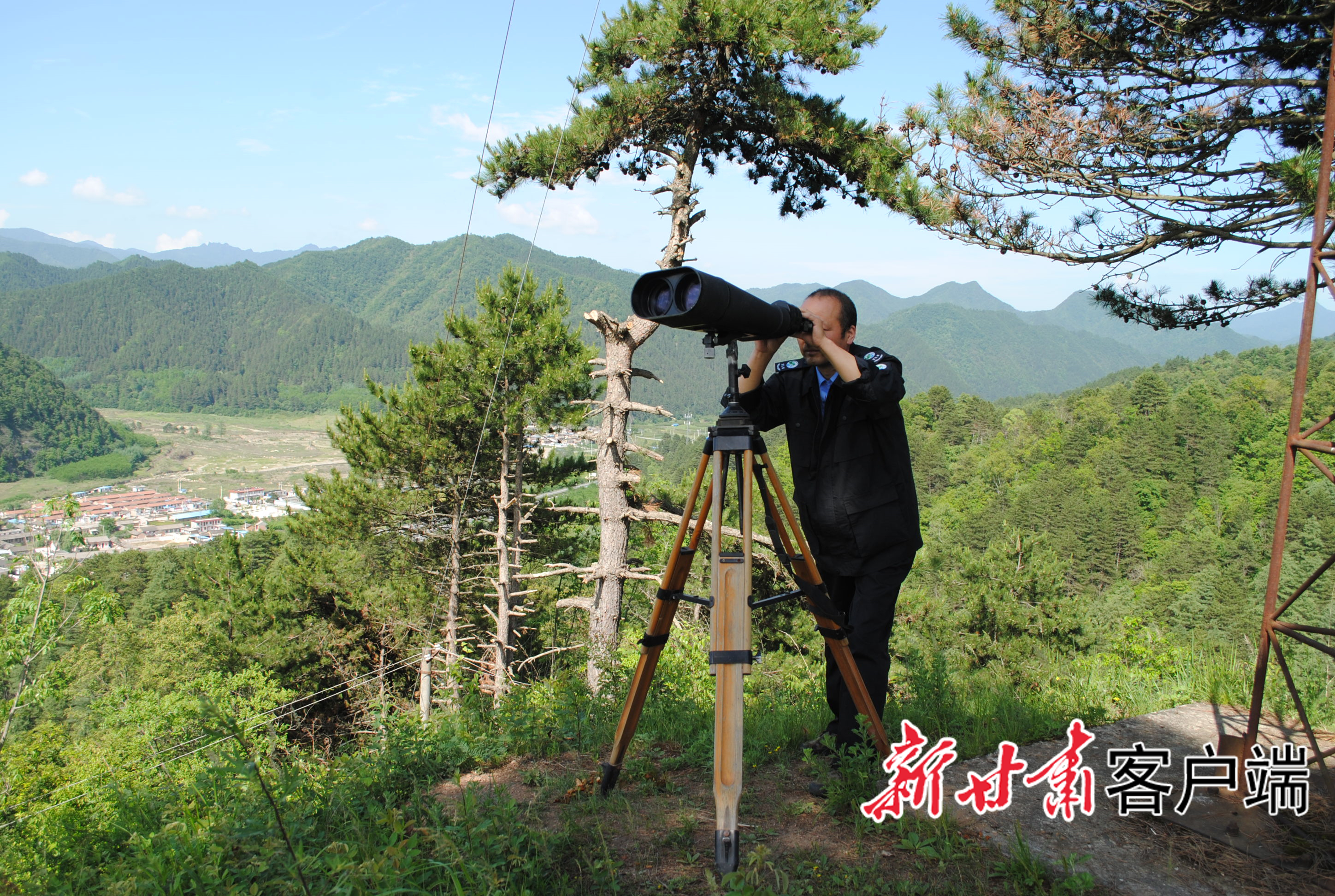 金国徽通过望远镜监控森林安全