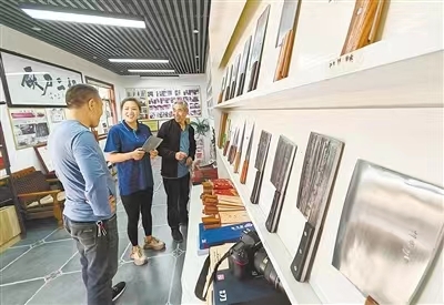 员工在胡二刀具厂展厅为顾客介绍刀具 姜涛 摄