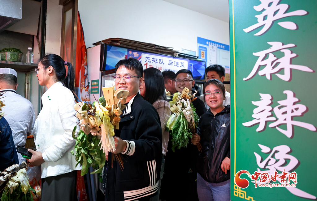 4月24日，在甘肃省天水市秦州区的天水名优小吃城，游客挑选好麻辣烫菜品后排队等待加工。