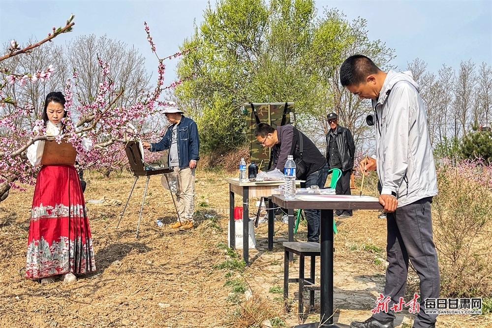 书画爱好者在桃园里写生 张春生 摄