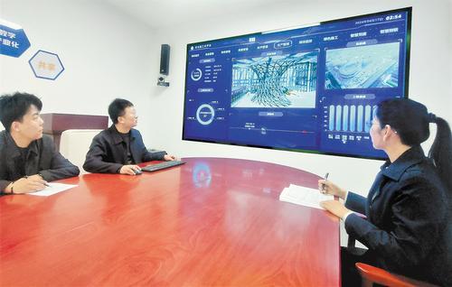 4月17日，河北建工集团数字化中心主任赵丽娅（右一）与同事一起察看河北建工云平台的项目应用情况。 河北日报记者 宋平摄