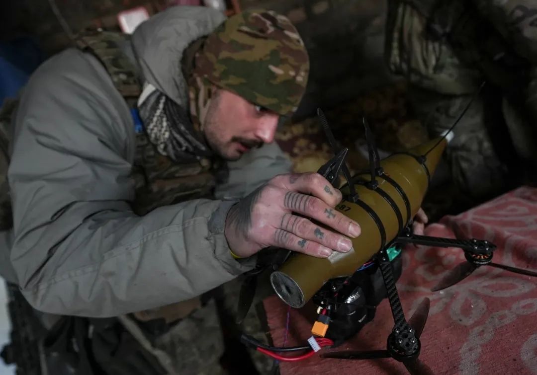 ▎2024年1月17日，在乌克兰顿涅茨克地区霍尔利夫卡镇附近的一个位置，第24独立机械化旅拉罗格无人机中队的一名乌克兰士兵正在将RPG-7榴弹发射器的炮弹安装到第一人称视角（FPV）无人机上。（图片来源：路透社）