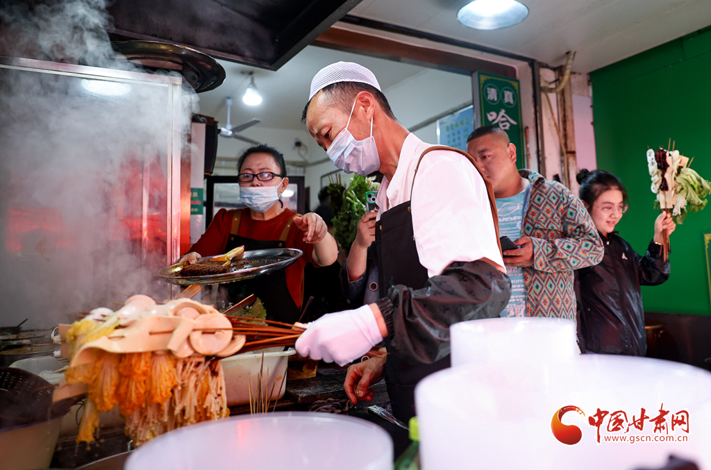 4月24日，在甘肃省天水市秦州区的天水名优小吃城一麻辣烫店，商家为游客加工麻辣烫。