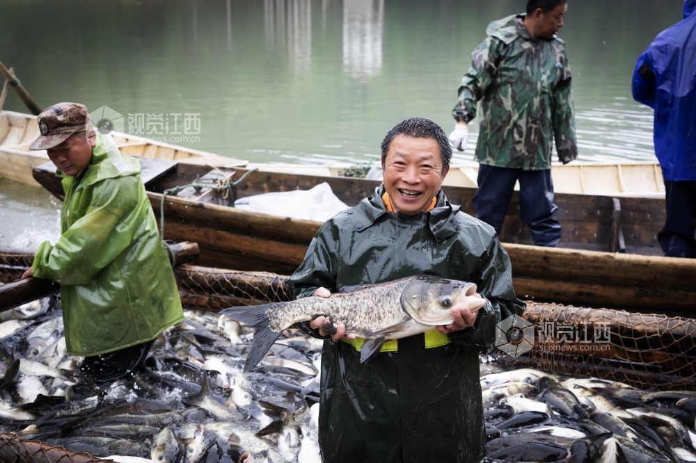渔民高兴地抱起捕获的大鱼。