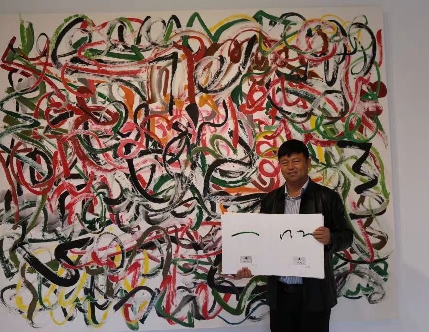 寒溪村村支书谢恩安在艺术作品《五百笔@浮梁》前，展示自己的一笔。他画的那笔意为绿水青山。新华每日电讯记者张典标摄