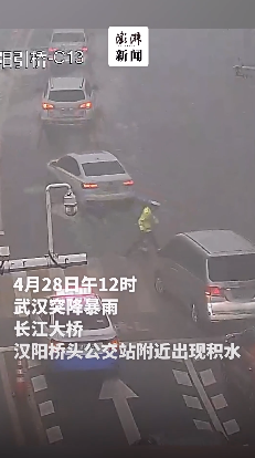 武汉突降暴雨 长江大桥交警徒手排积水疏导交通