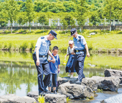 湖北省长阳土家族自治县公安局民警提醒学生外出游玩时注意安全。  胡 灿摄（人民视觉）