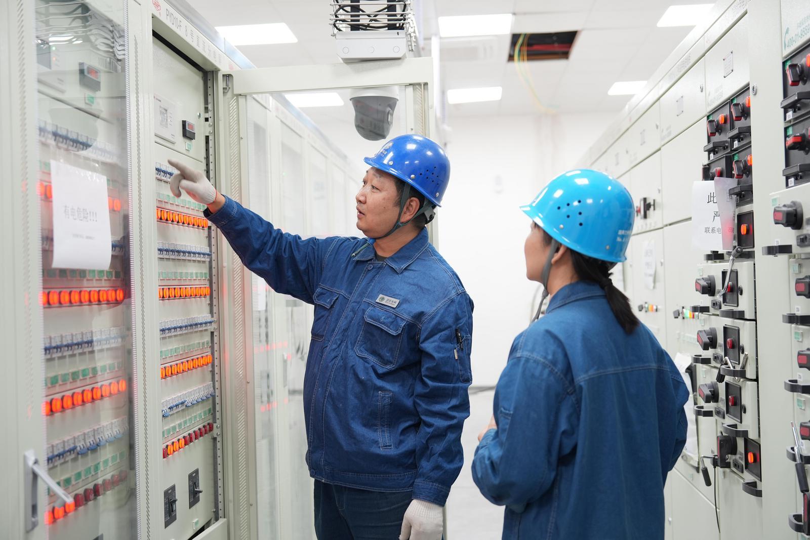 国网兰州供电公司变电检修二次人员金明杰和同事对330千伏百合变电站一体化电源进行验收工作