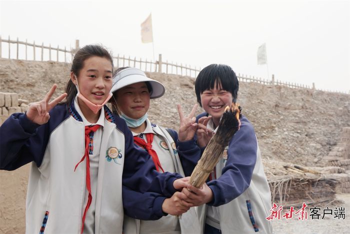 研学学生在用自己钻木取火产生的火种点燃火把