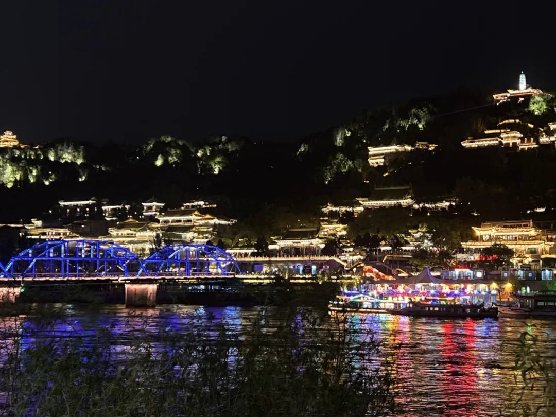 兰州百年铁桥霓虹闪烁，滔滔黄河流光溢彩。（图源：@泽梁S）