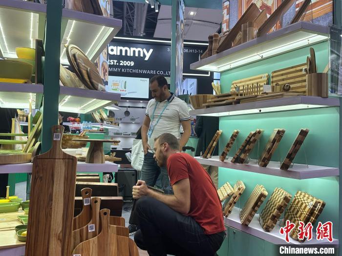 4月25日，境外采购商在第135届广交会了解中国企业展出的木质砧板。中新社记者 程景伟 摄